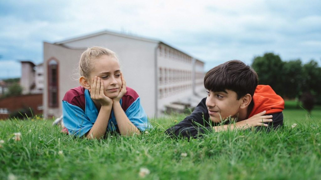 Scrapper Review - Georgie and Ali lie on the grass